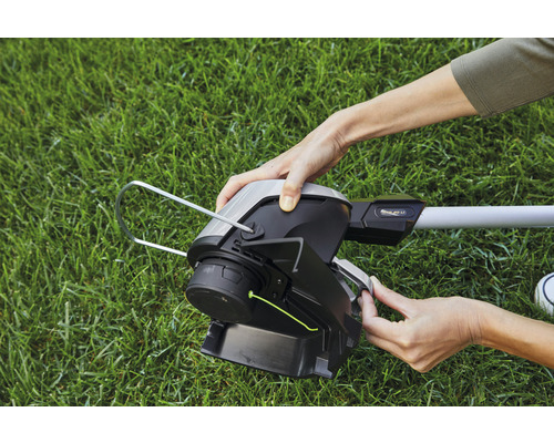 Nahaufnahme einer Person, die einen Rasentrimmer bedient.