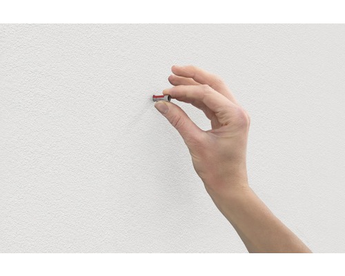 Main insérant une cheville dans un mur