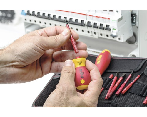 Mann wechselt Wiha Schraubendreher-Bit vor Verteilerkasten