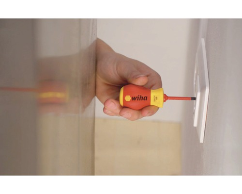 Ein Mann schraubt mit einem Wiha Schraubendreher eine Steckdose fest.