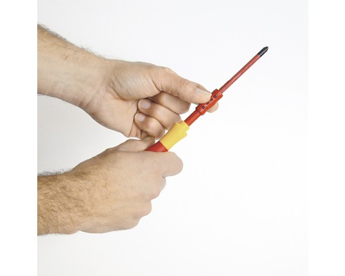 Eine Person hält einen Schraubendreher in der Hand.