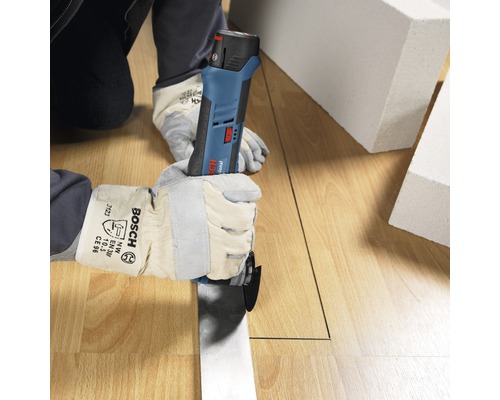 Une personne coupe un sol stratifié avec un outil multifonction Bosch.