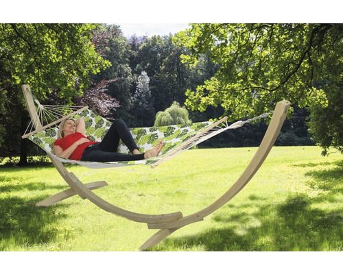 Femme se détend dans un hamac avec cadre en bois et motif de feuilles dans le jardin.