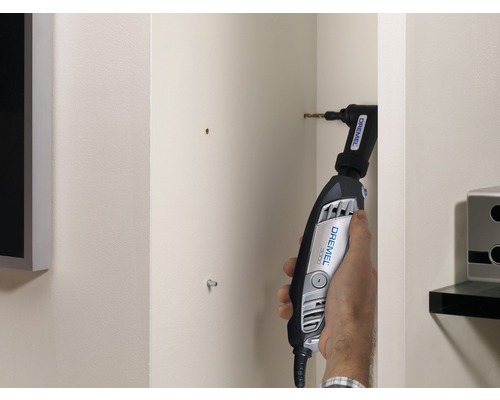 Eine Person verwendet einen Dremel 3000 mit Winkelvorsatz zum Bohren in eine Wand.