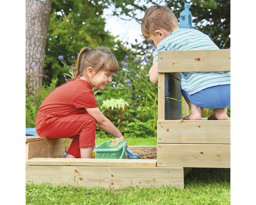 Zwei Kinder spielen in einem Sandkasten aus Holz im Garten.
