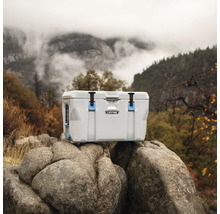 Kühlbox auf Felsen mit Berglandschaft im Hintergrund