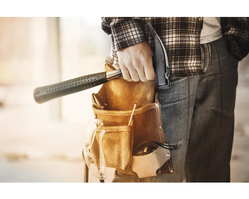 Handwerker mit Hammer im Werkzeuggürtel
