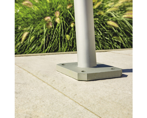 Vue détaillée d''un luminaire de jardin argenté avec une base carrée sur un sol en pierre