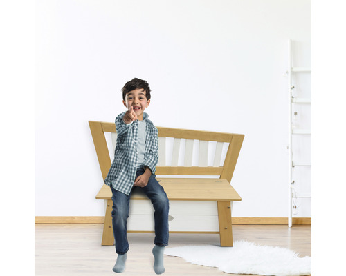 Enfant assis sur un banc en bois avec espace de rangement dans la chambre d''enfant