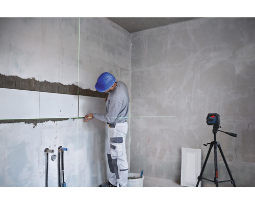 Artisan carreleur utilisant un laser lignes croisées sur un chantier