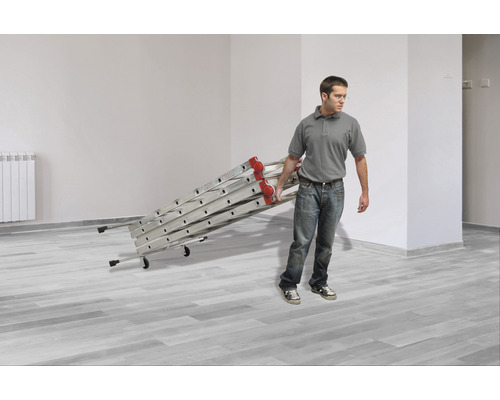 Mann trägt eine Aluminium Mehrzweckleiter in einem Raum.
