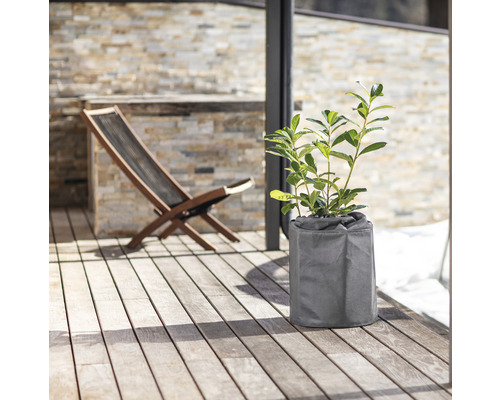 Plante dans un pot gris sur une terrasse avec platelage en bois et une chaise longue