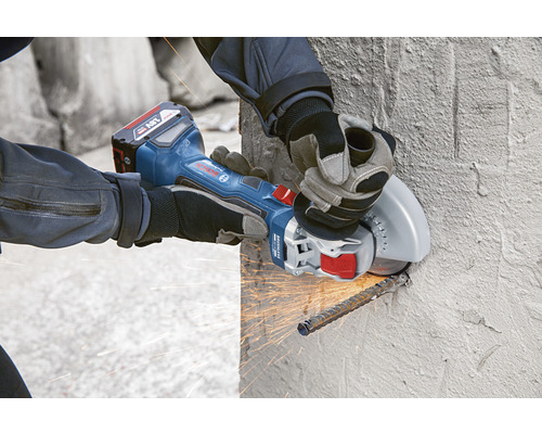 Meuleuse d'angle à batterie en cours d'utilisation pour couper de l'acier d'armature dans un mur en béton