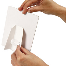 Une personne fixe un support blanc au dos d''une plaque blanche.