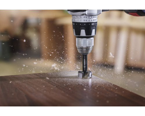 Perceuse sans fil avec mèche Forstner perçant dans du bois avec des copeaux