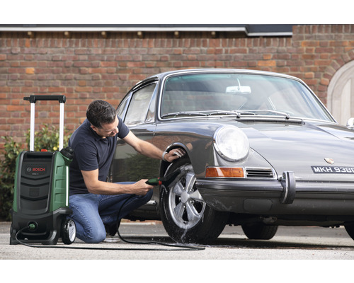 Homme nettoyant une voiture avec un nettoyeur haute pression de Bosch