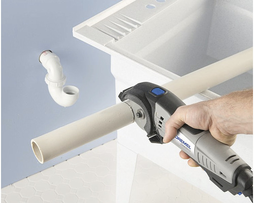 Outil Dremel coupant un tuyau devant un évier