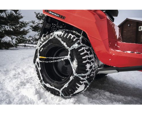 Roue d''un tracteur de pelouse avec chaînes à neige en hiver