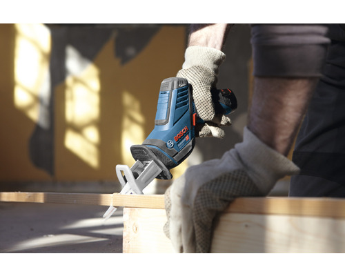 Artisan sciant une planche de bois avec une scie sabre sans fil Bosch