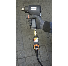 Druckluft-Schlagschrauber mit Manometer in der Hand