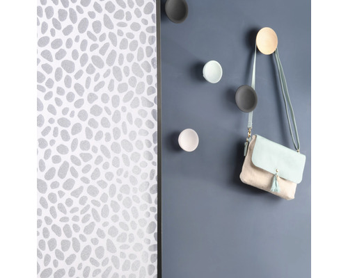 Wand mit Mustertapete und runden Wandhaken mit Handtasche