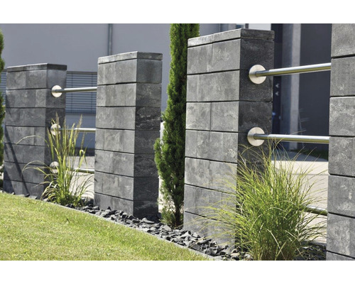 Vue de jardin avec clôture en blocs de béton et rambarde en acier inoxydable