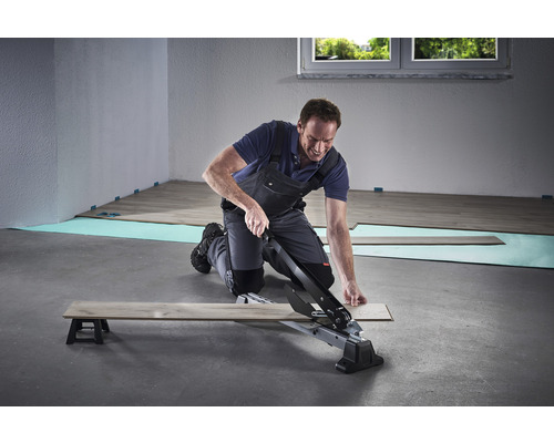 Mann schneidet Laminat mit einem Laminatschneider.