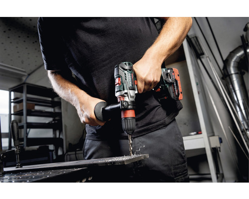 Mann bohrt mit einer Metabo Akku-Bohrmaschine in ein Metallstück.