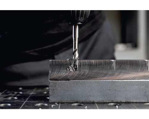 Metallbohrer bohrt Loch in Metallblock