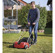 Mann benutzt einen Rasenlüfter im Garten.