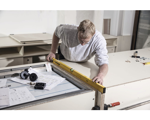 Handwerker prüft mit einer Wasserwaage die Nivellierung eines Werkstücks.