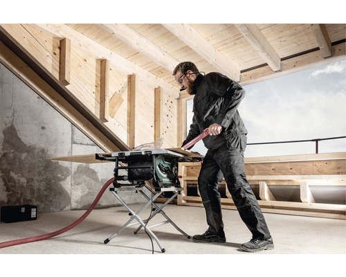Handwerker bei der Arbeit mit einer Tischkreissäge in einem Rohbau