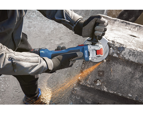 Eine Person benutzt einen Akku-Winkelschleifer zum Schleifen von Beton.