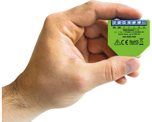 Une main tenant un Shelly Dimmer 2 pour la domotique