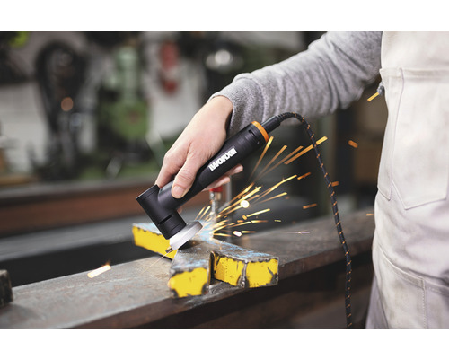 Une personne utilise une meuleuse d''angle de la marque WORX pour travailler le métal, avec des étincelles.