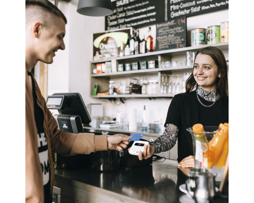 Un client paie avec une carte de crédit à la caisse d''un magasin.