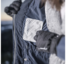 Personne plaçant un patch chauffant dans une poche de veste