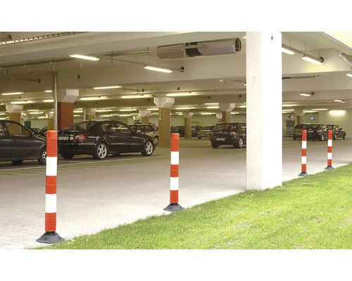Scène d''un parking souterrain avec plusieurs voitures garées et des poteaux d''avertissement rouges et blancs