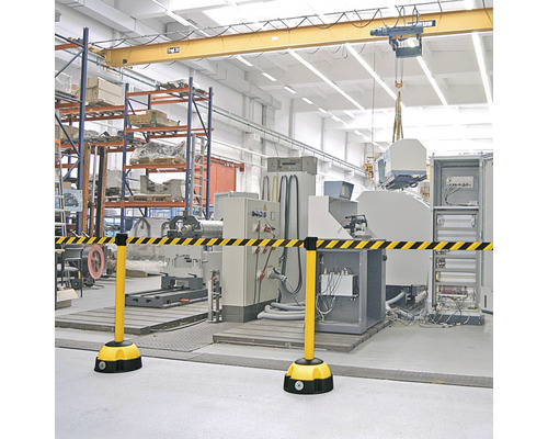 Bande de signalisation jaune et noire dans un hall d''usine pour indiquer une zone dangereuse