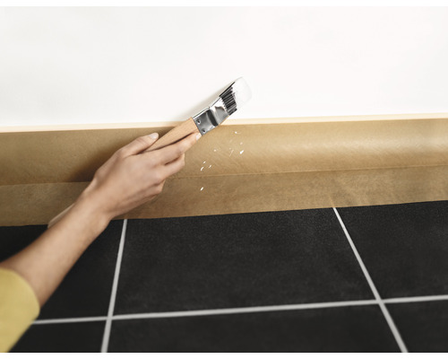 Anstreichen einer Wand mit Pinsel und Abdeckband zum Schutz des Bodens