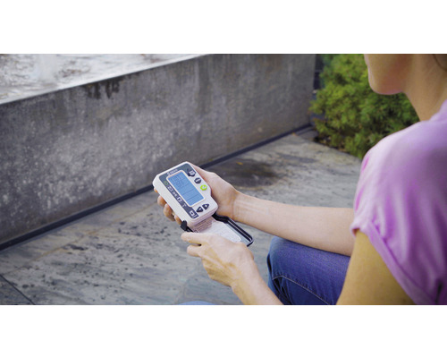 Eine Person hält ein Gardena-Bodenfeuchtigkeitsmessgerät in der Hand