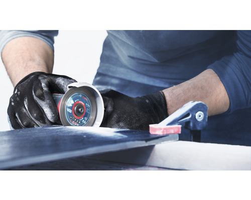 Handwerker schneidet Fliese mit Trennschleifer