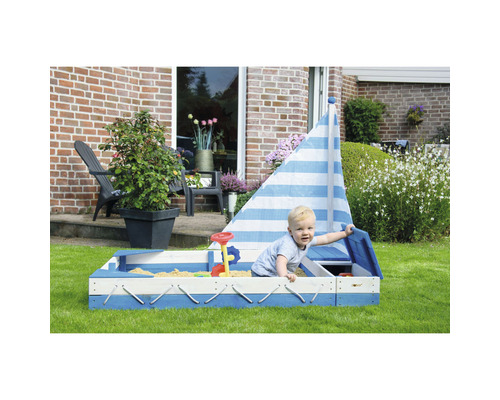 Bac à sable pour enfants en forme de voilier avec jouets dans le jardin