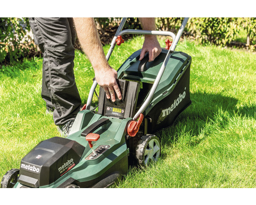 Tondeuse autoportée avec batterie insérée sur une pelouse