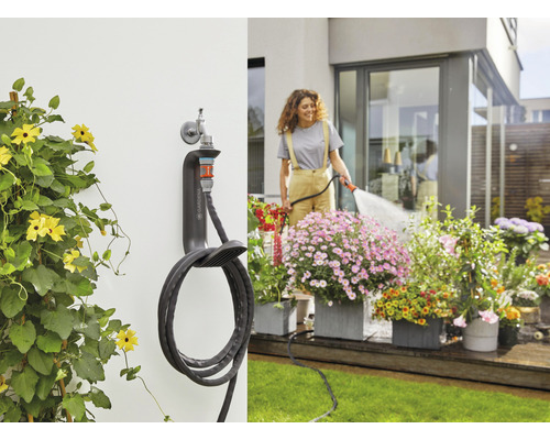 Scène de jardin avec un dévidoir mural et une femme arrosant des fleurs