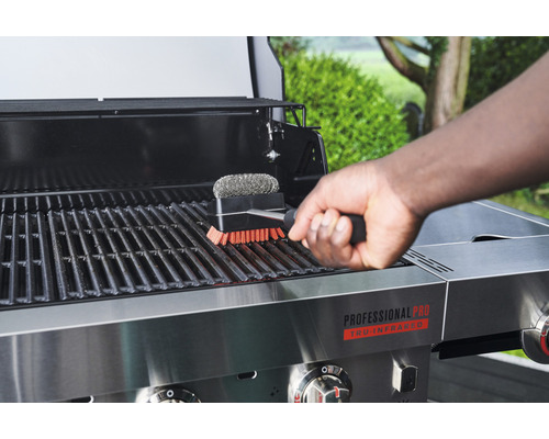 Personne nettoyant une grille de barbecue avec une brosse pour barbecue