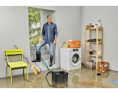 Überfluteter Kellerraum mit Mann auf Treppe, Waschmaschine und Regalen