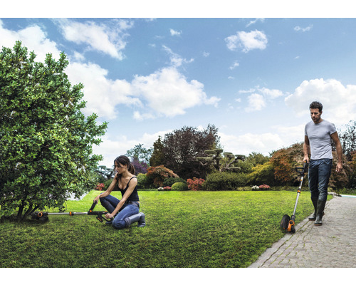 Gartenszene mit Rasentrimmern bei der Arbeit im Garten.