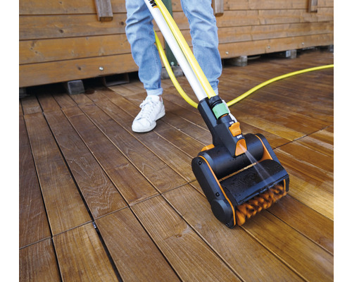 Nettoyeur de terrasse en cours d''utilisation sur une terrasse en bois avec une personne
