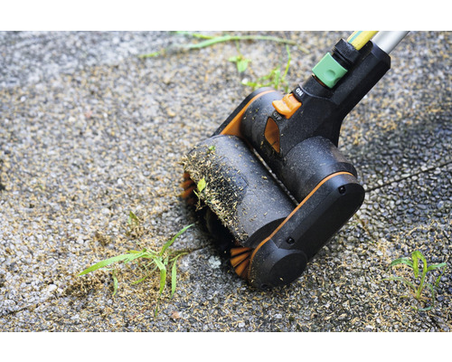 Brosse de jointoiement en cours d''utilisation sur des pavés pour l''élimination des mauvaises herbes